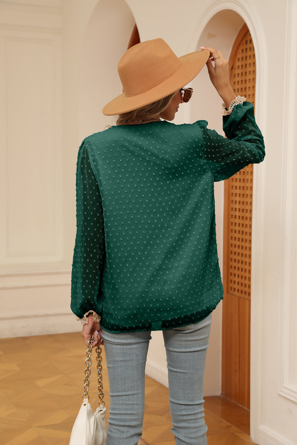 Green swiss-dot V-neck blouse with cream trim and buttoned cuffs, back