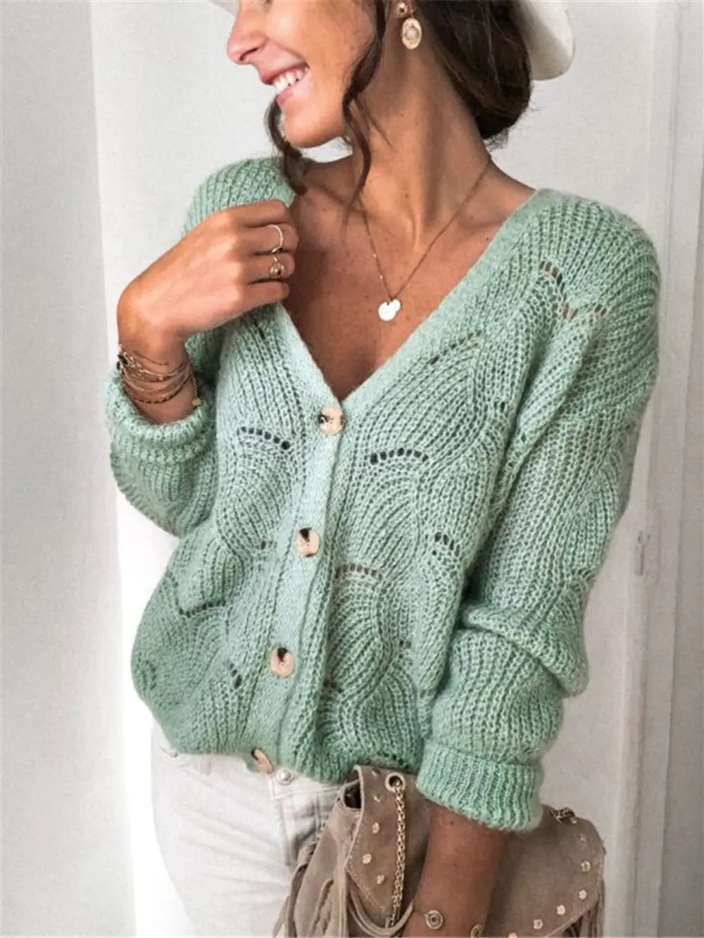 Light green openwork button-up cardigan with V-neck and long sleeves, knit eyelet detail.