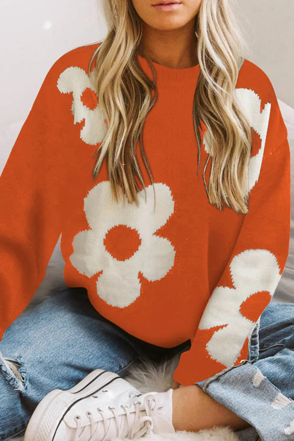 Orange long-sleeve sweater with round neck and oversized white floral motif