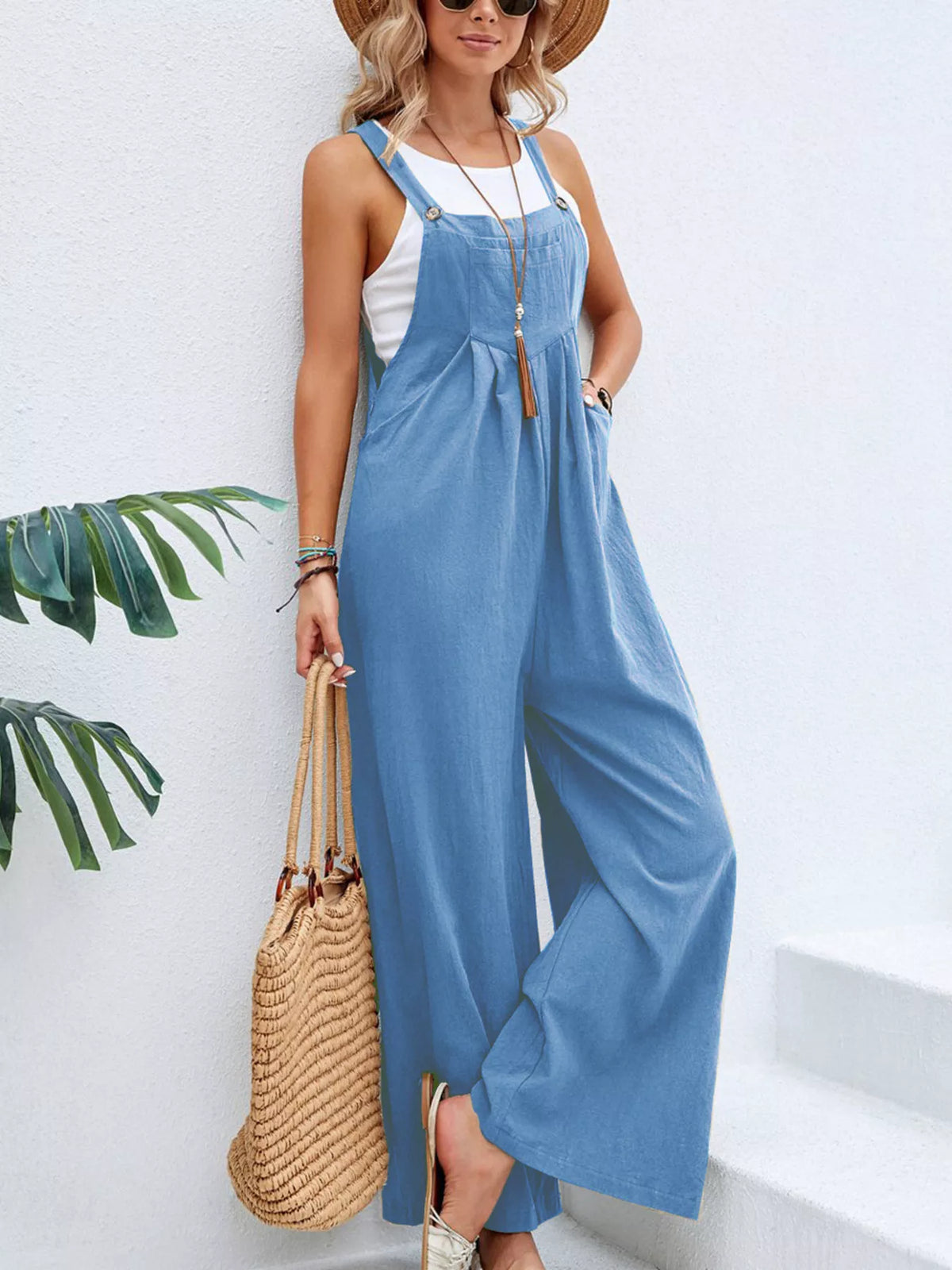 Sleeveless wide-leg overalls with pockets, adjustable straps, light blue overall bib.