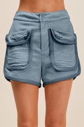 Denim blue mineral-washed terry high-rise cargo shorts close-up, back flap cargo pockets