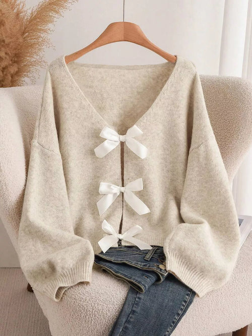 Light beige knit cardigan with V-neck and three white bow accents at front