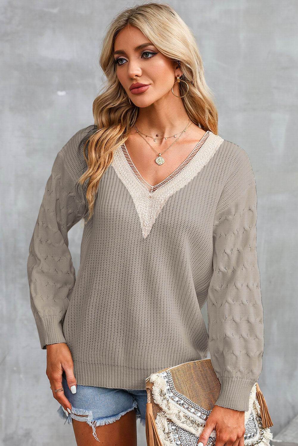 Khaki V-neck sweater with cream contrast neckline trim and long puff sleeves