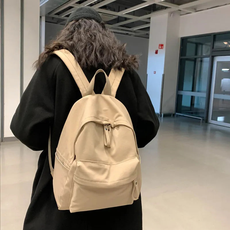 Ivory cotton zip backpack with top handle, front pocket, and adjustable straps