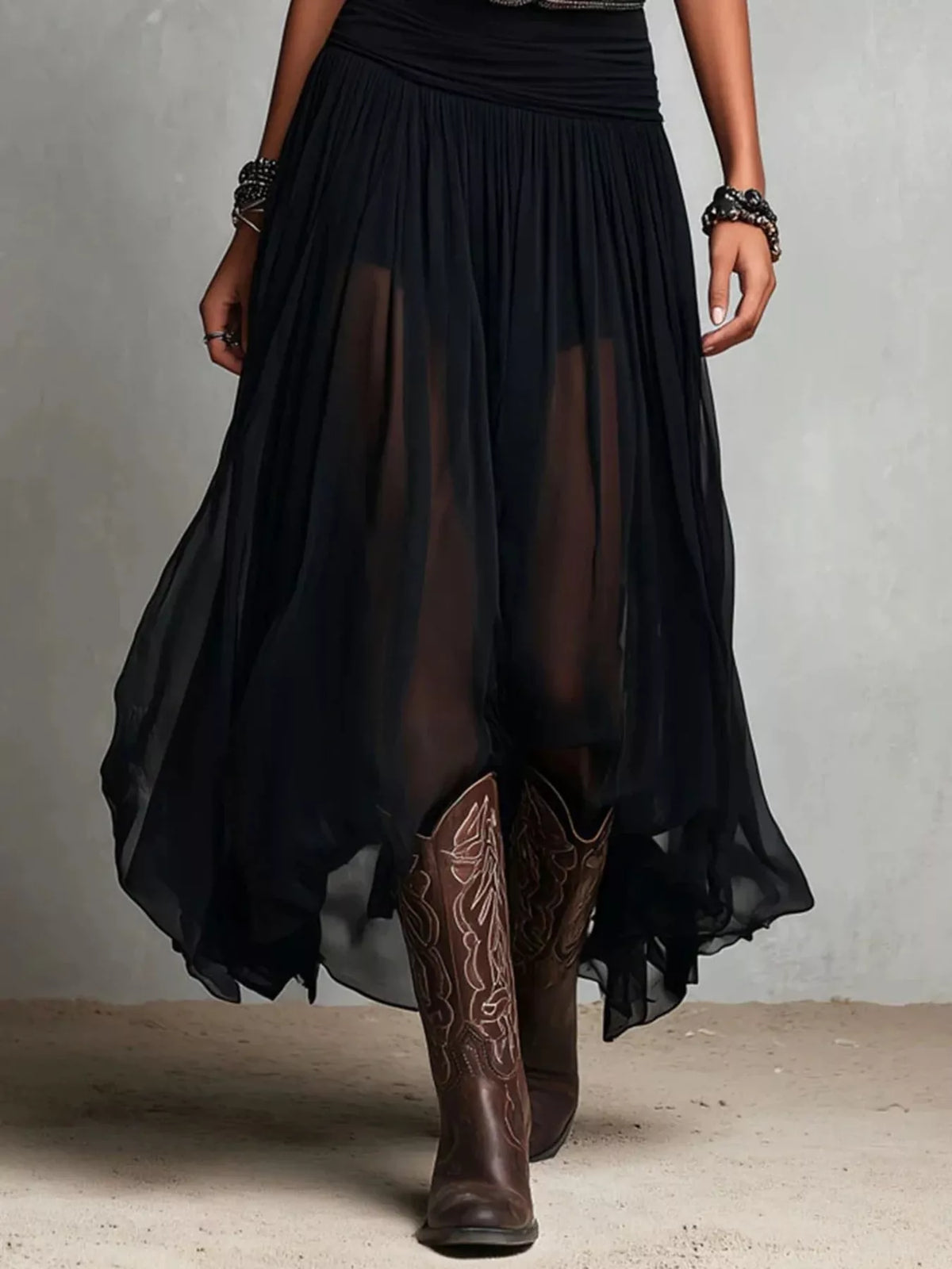 Black sleeveless maxi dress hem view: layered pleats and western belt at waist