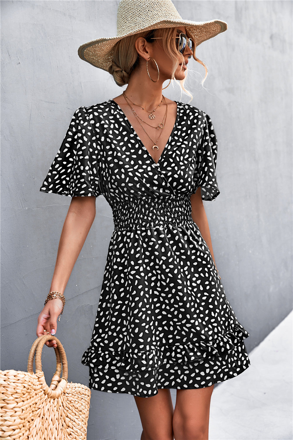 Black surplice mini dress with white abstract print, puff short sleeves, smocked waist, flared skirt