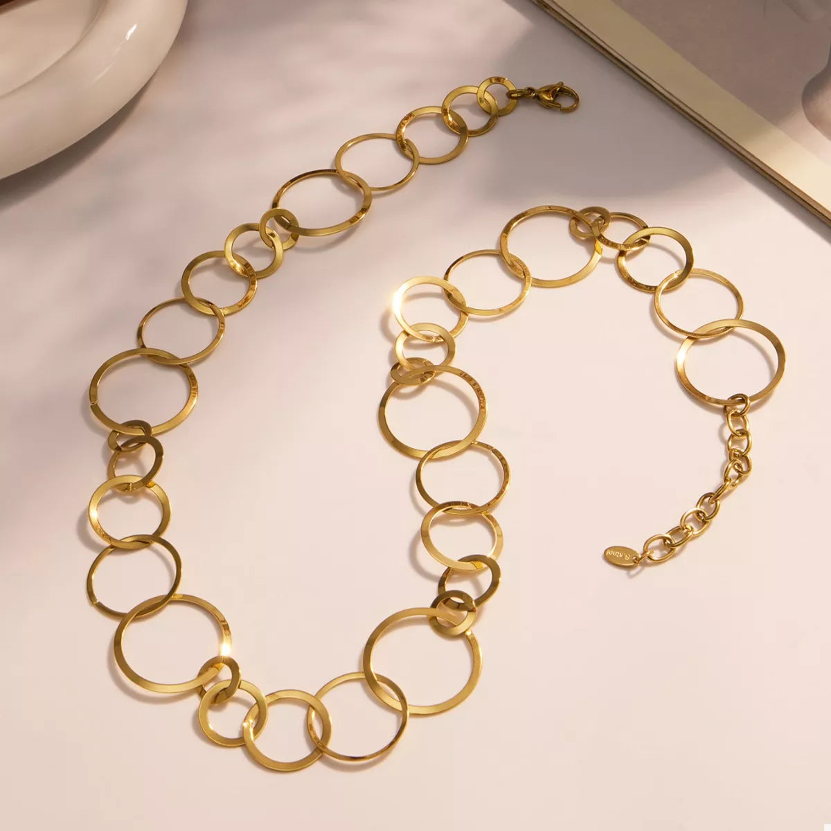 Gold-plated oval-link statement necklace laid flat with clasp visible