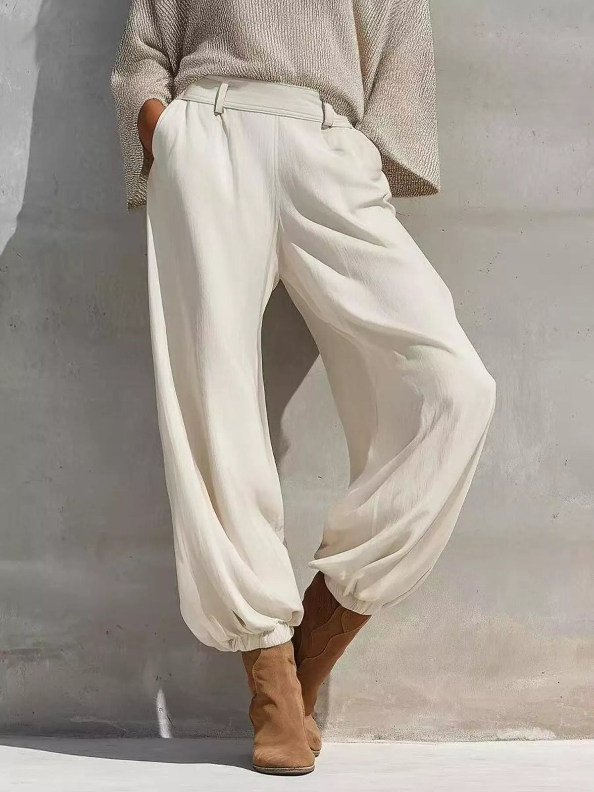 High-waisted white jogger pants with elastic cuffs and draped knit top in gray tone