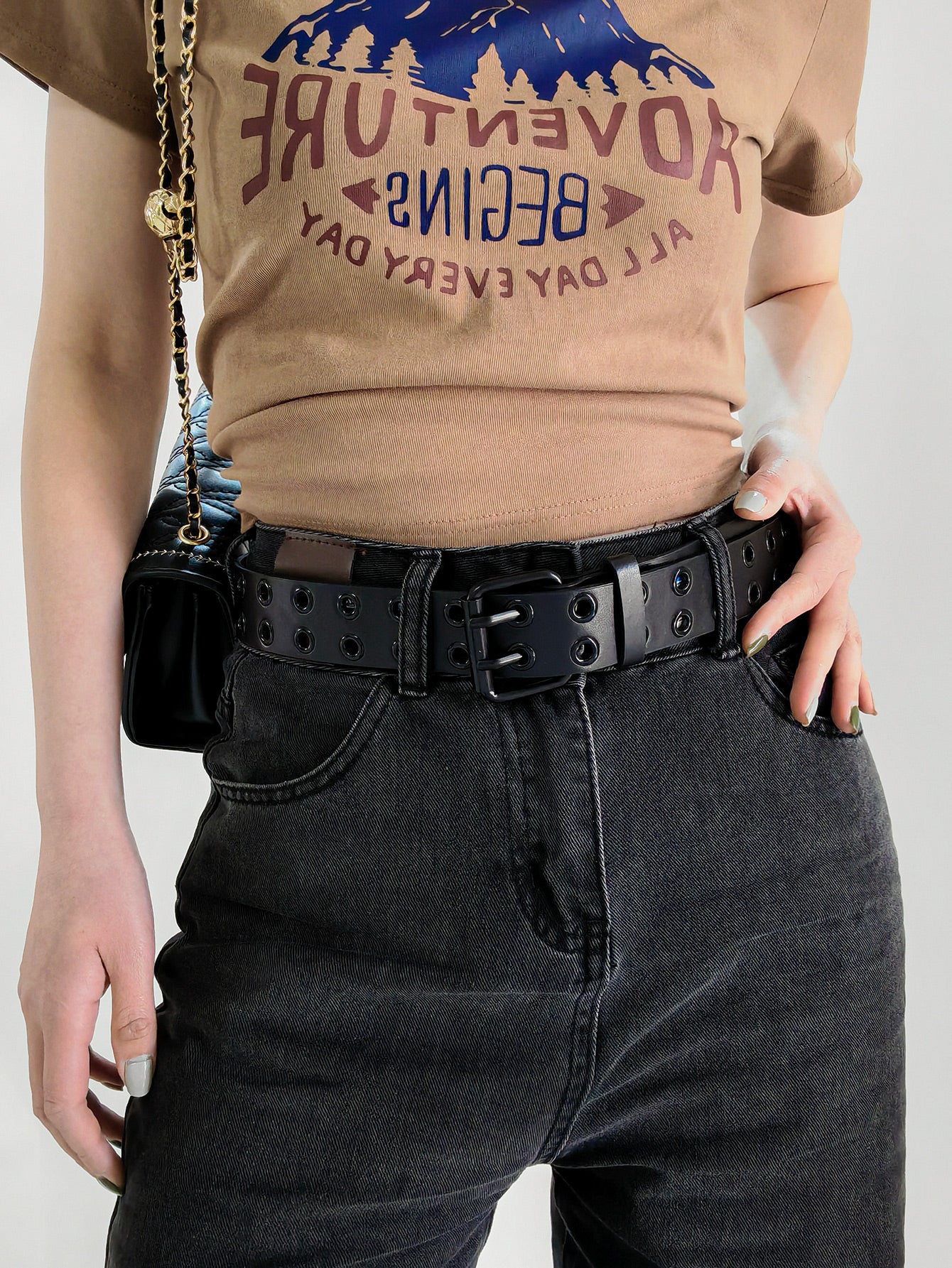 Black vegan leather grommet belt with square buckle on dark denim waist