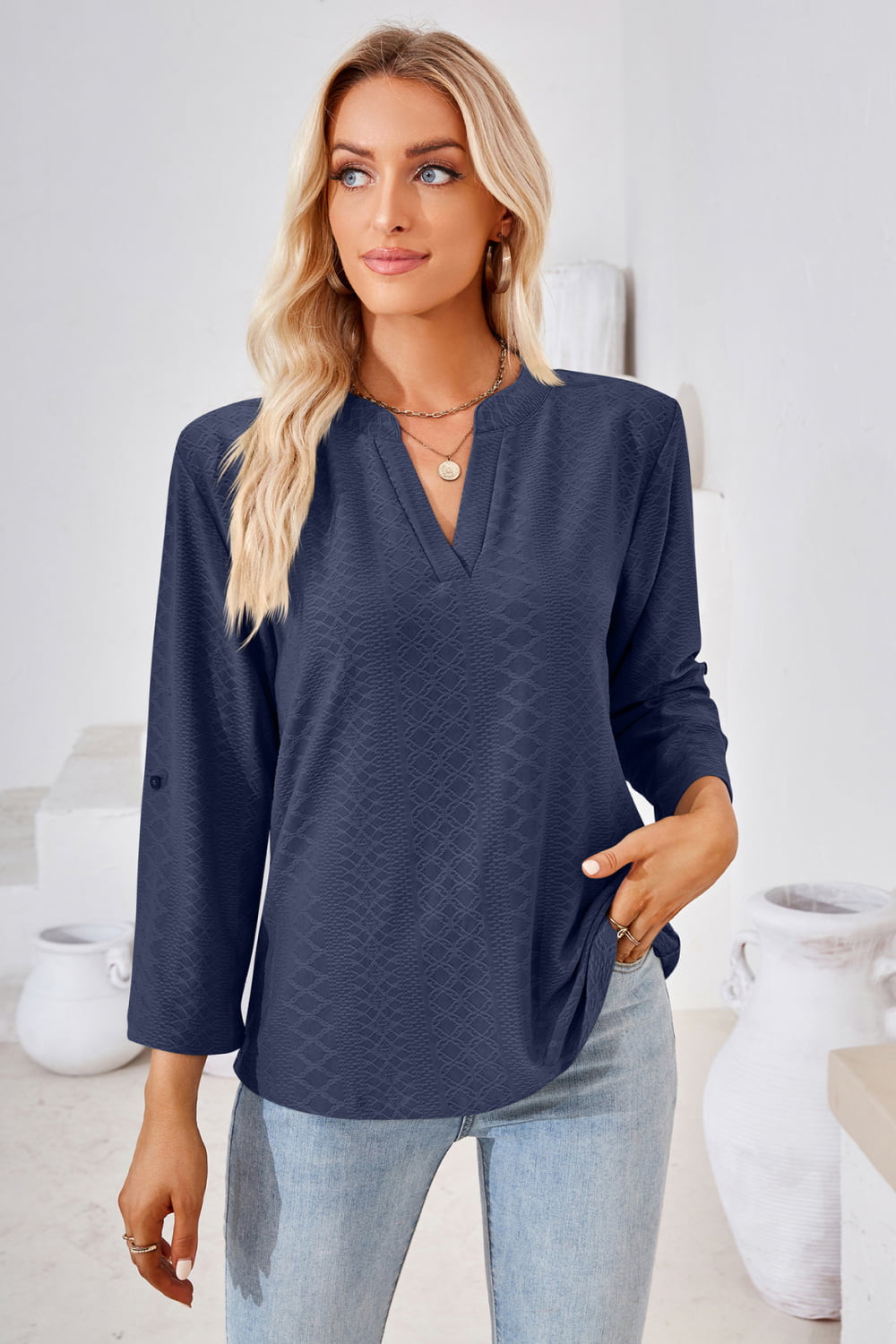 Dark blue V-neck blouse with roll-tap sleeves and textured front