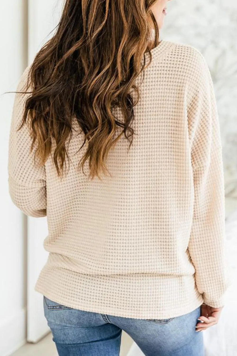 Cream waffle knit long sleeve henley top with button placket and curved hem
