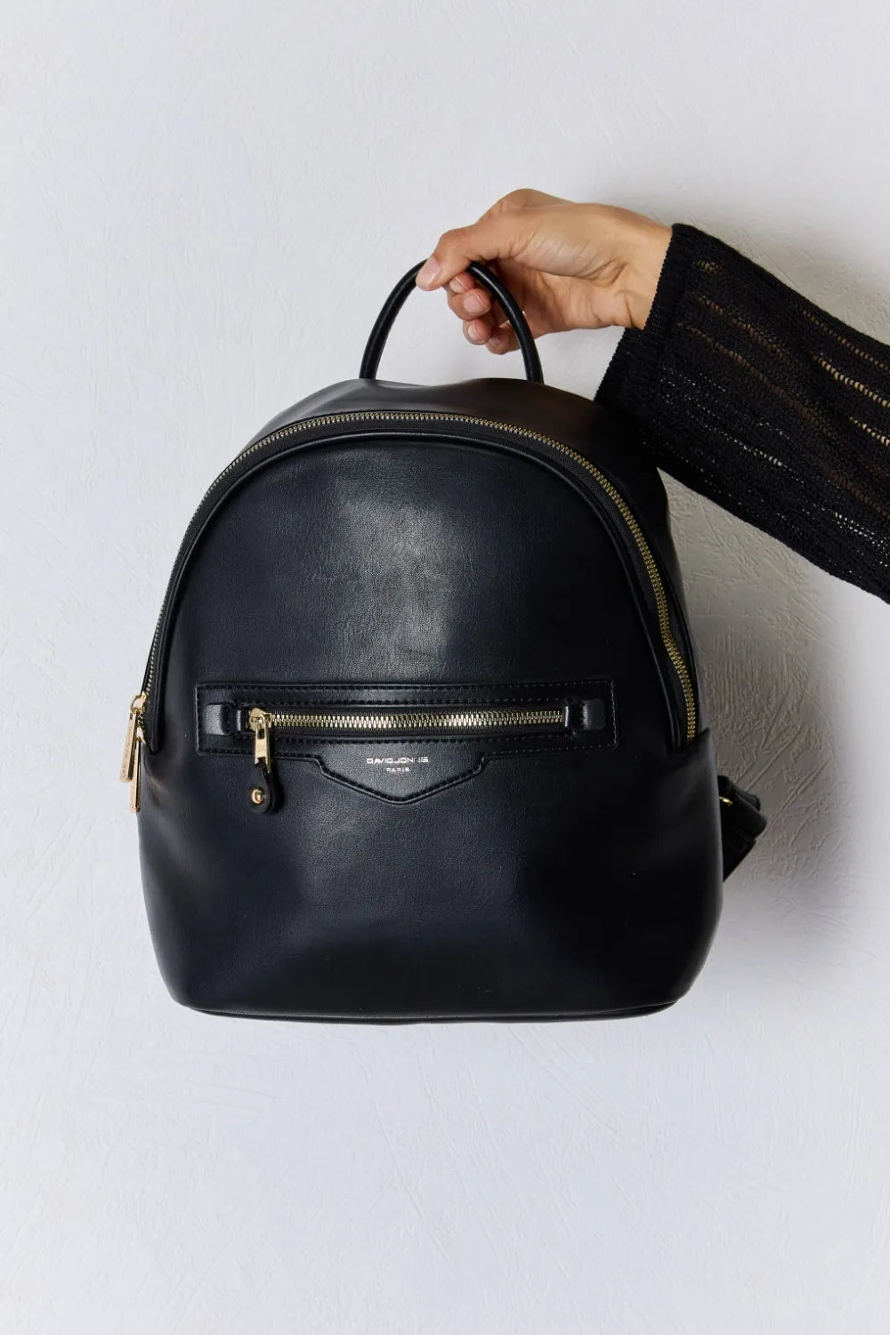 Black vegan leather mini backpack with curved top handle and front zip pocket