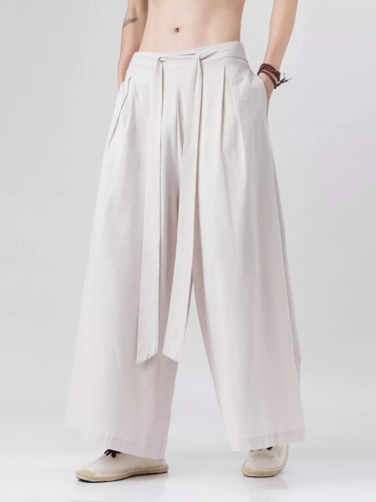 Ivory wide-leg pants showing waistband pleats and wide flowing legs