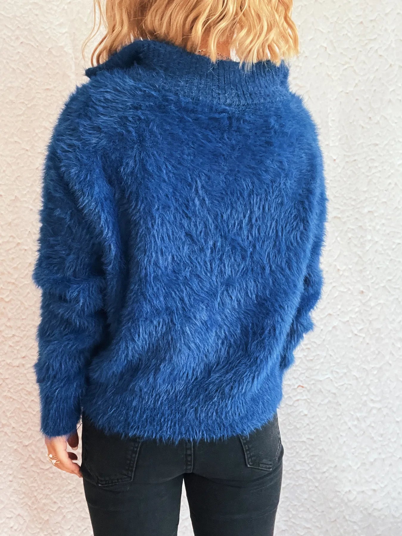 Back view of a blue fuzzy half-zip sweater with long sleeves