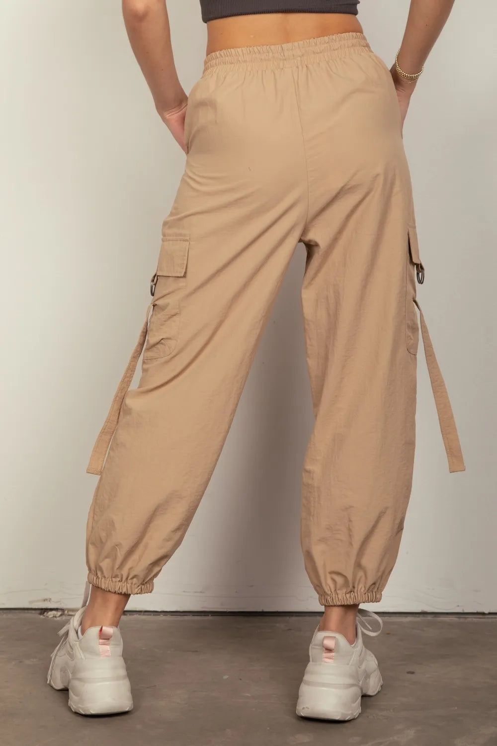 Taupe elastic waist cargo pants with flap cargo pockets and hanging tie details
