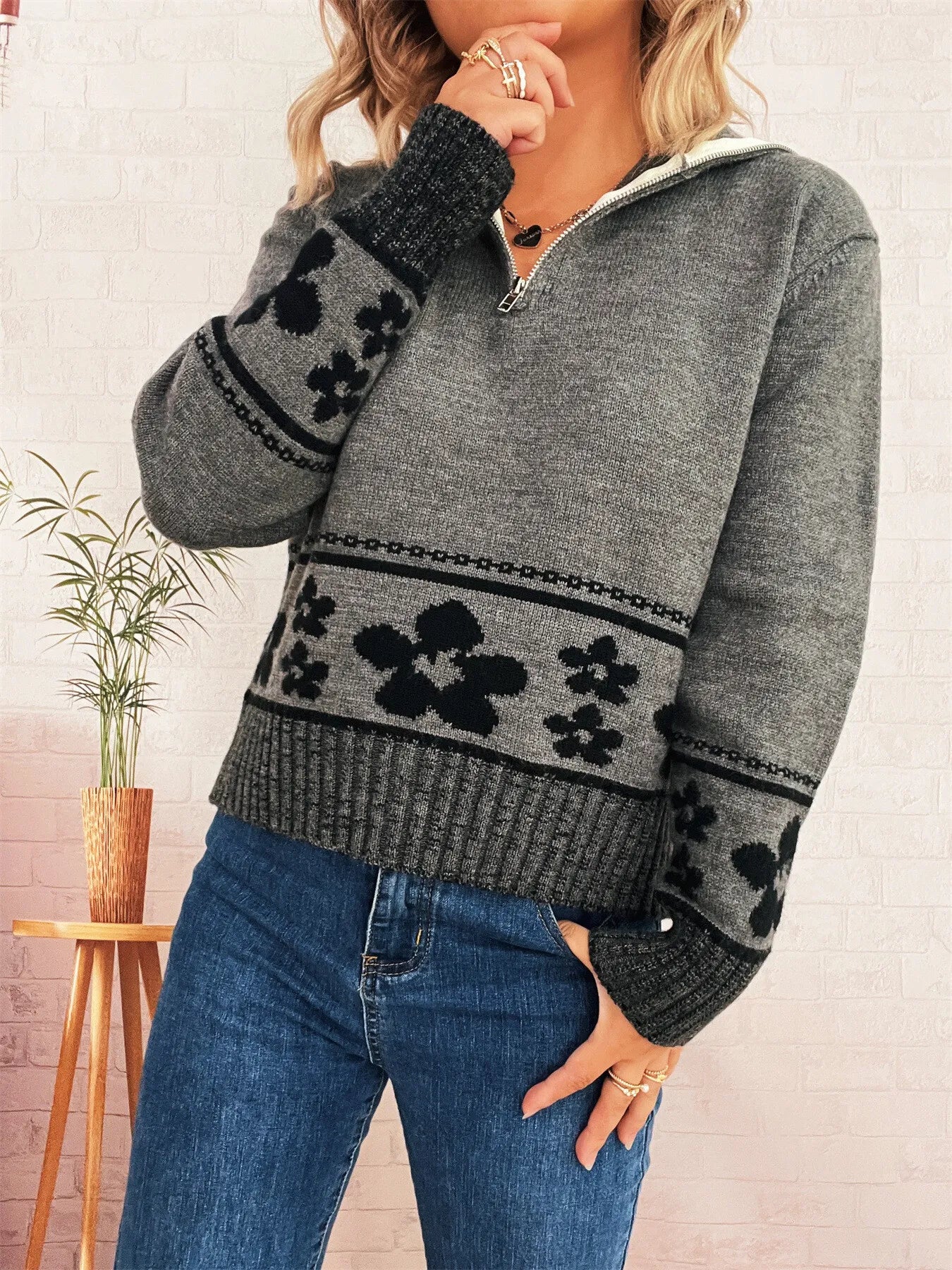 Gray zip-collar long-sleeve sweater with black flower motif stripe and ribbed knit hem