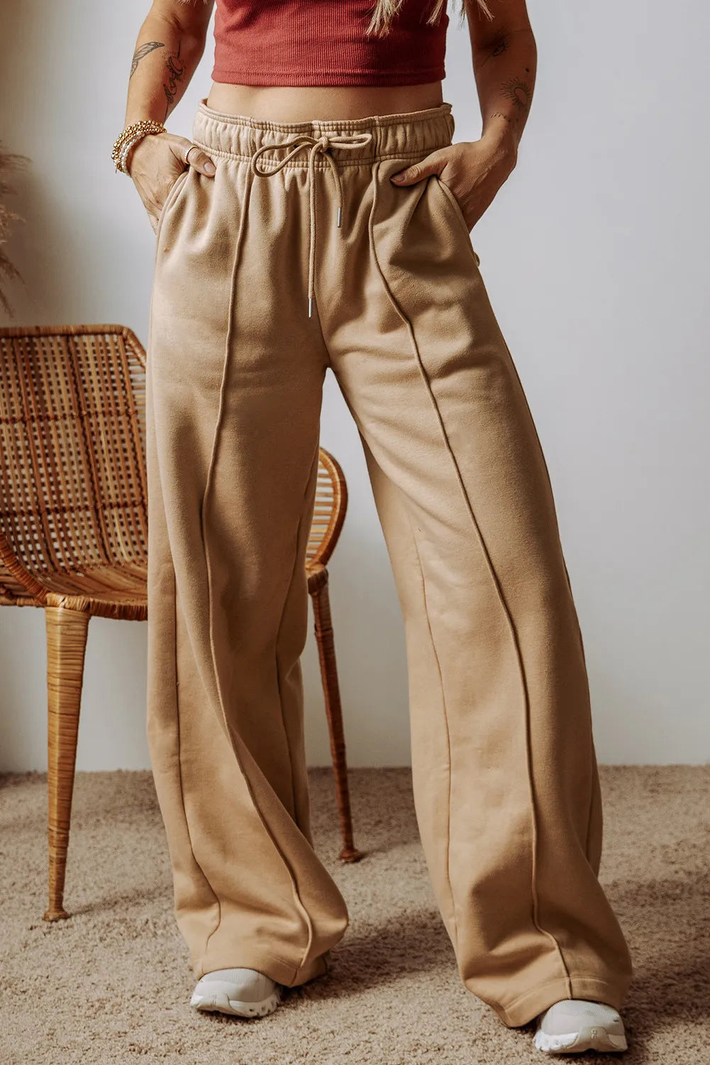 Tan wide-leg drawstring pants with side pockets and an elastic waistband