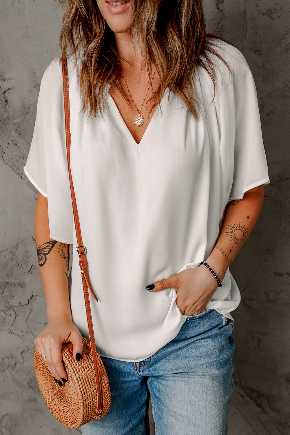White flutter sleeve blouse with notched V neckline and soft, flowing fit