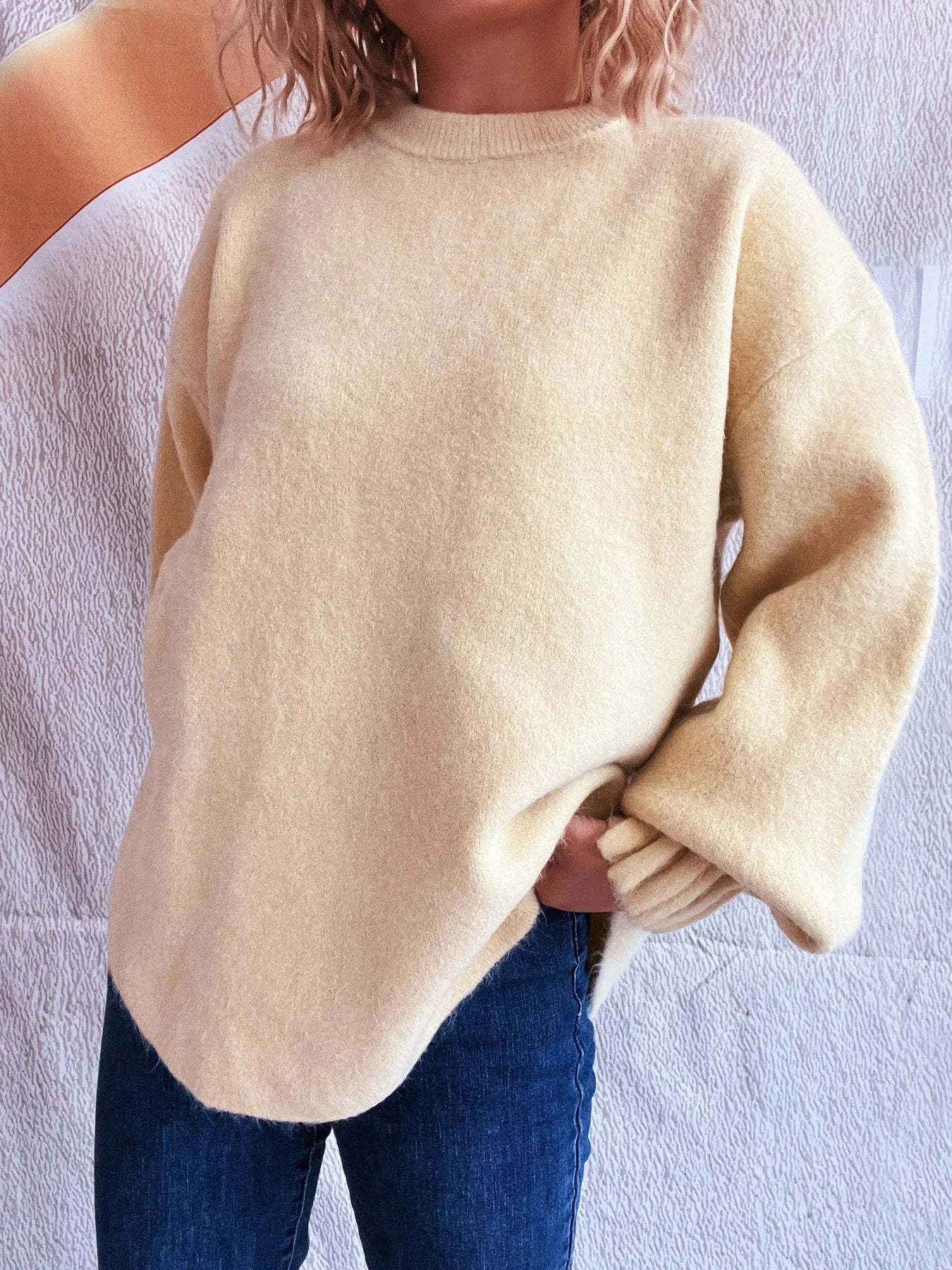 Cream round neck dropped-shoulder sweater, side view with ribbed cuffs