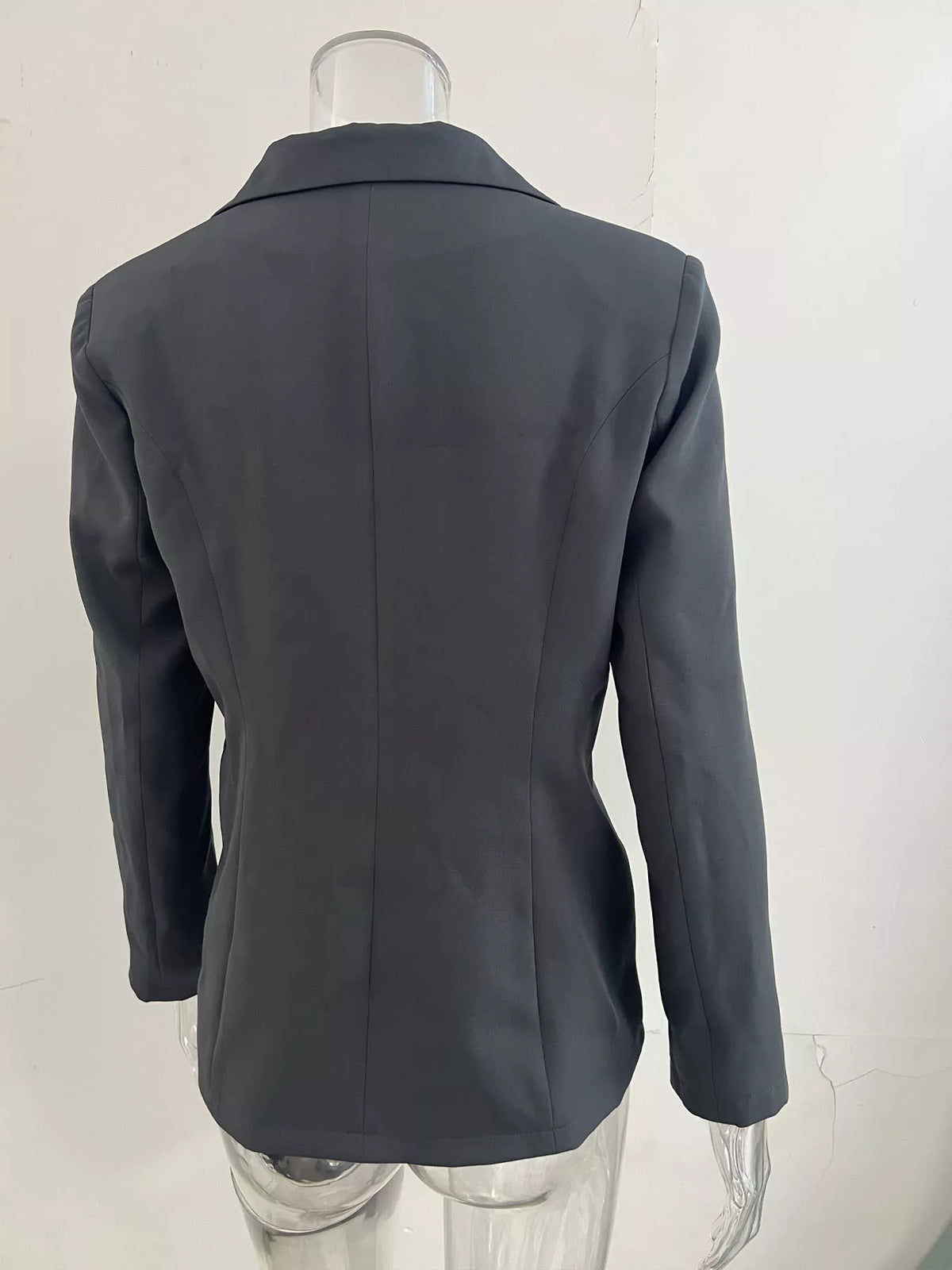 Dark gray slim-fit blazer back view on mannequin, center back seam.