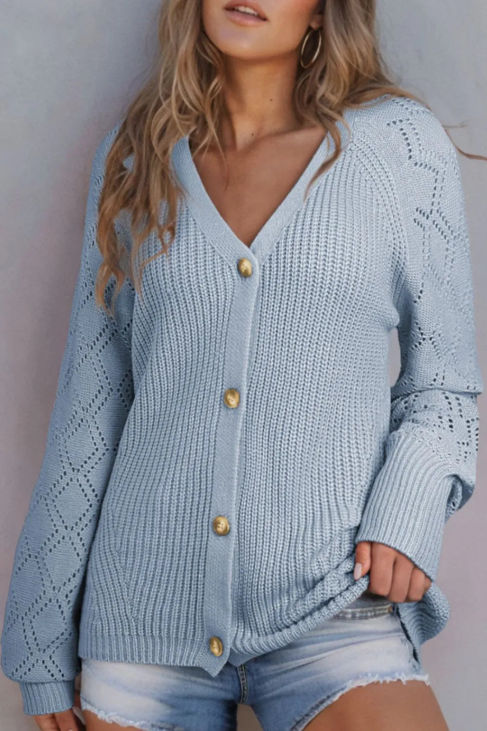 Light blue openwork V-neck cardigan with gold buttons, ribbed cuffs, and long sleeves