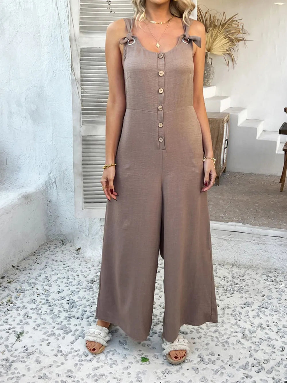 Taupe button-front wide-leg jumpsuit with knotted straps and sleeveless bodice