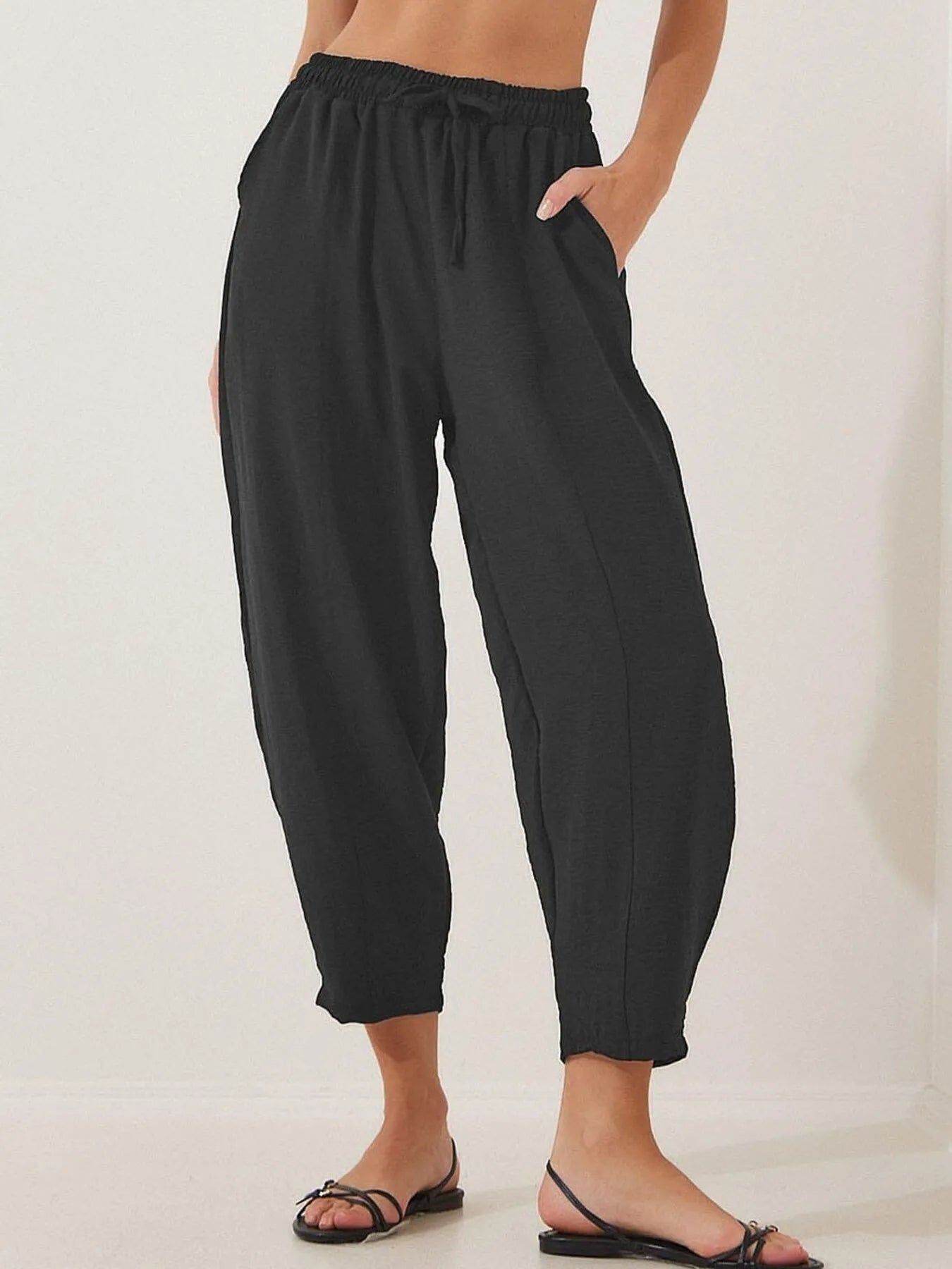 Black cropped wide-leg drawstring pants with elastic waistband and wide ankle hems