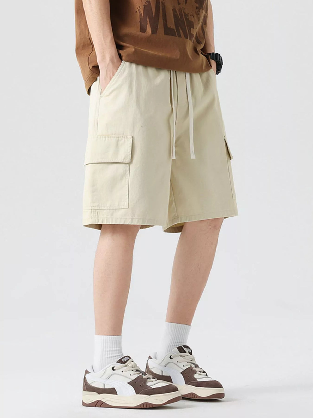 Men's light khaki drawstring cargo shorts with side pockets and knee-length cut.
