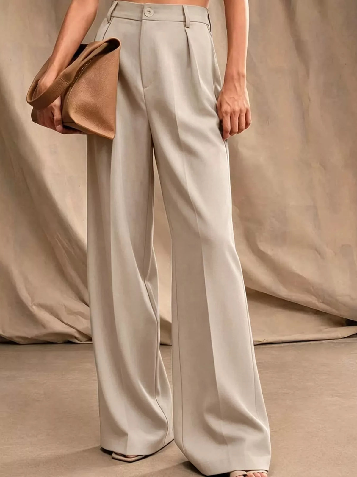 Off-white high-waisted pleated wide-leg pants with side seams and button closure
