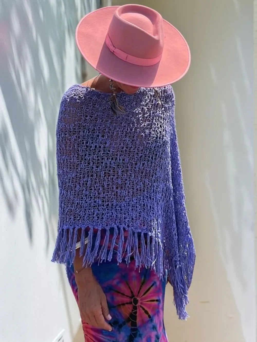 Purple open-knit shawl with boat neck and hanging fringe along hem