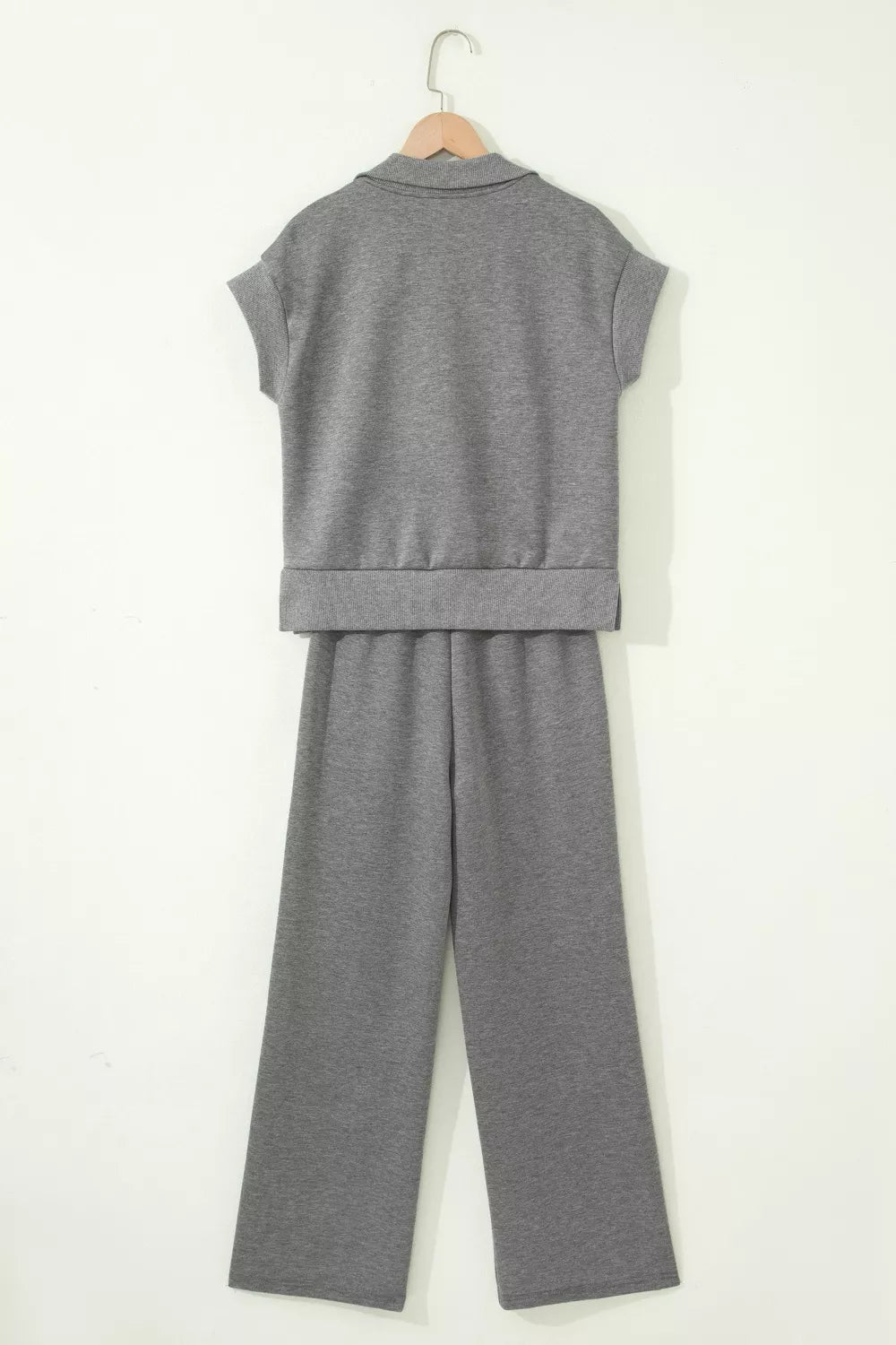 Dark gray two-piece set on hangers: back of polo top and wide-leg pants.