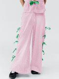 Blush pink plaid pants with green side ties and wide-leg hem