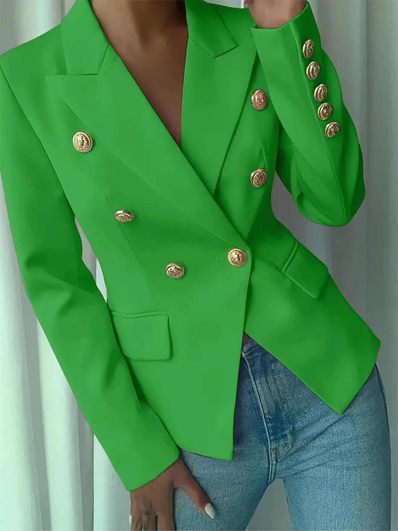 Green blazer with notch lapel, gold decorative buttons, and front flap pocket