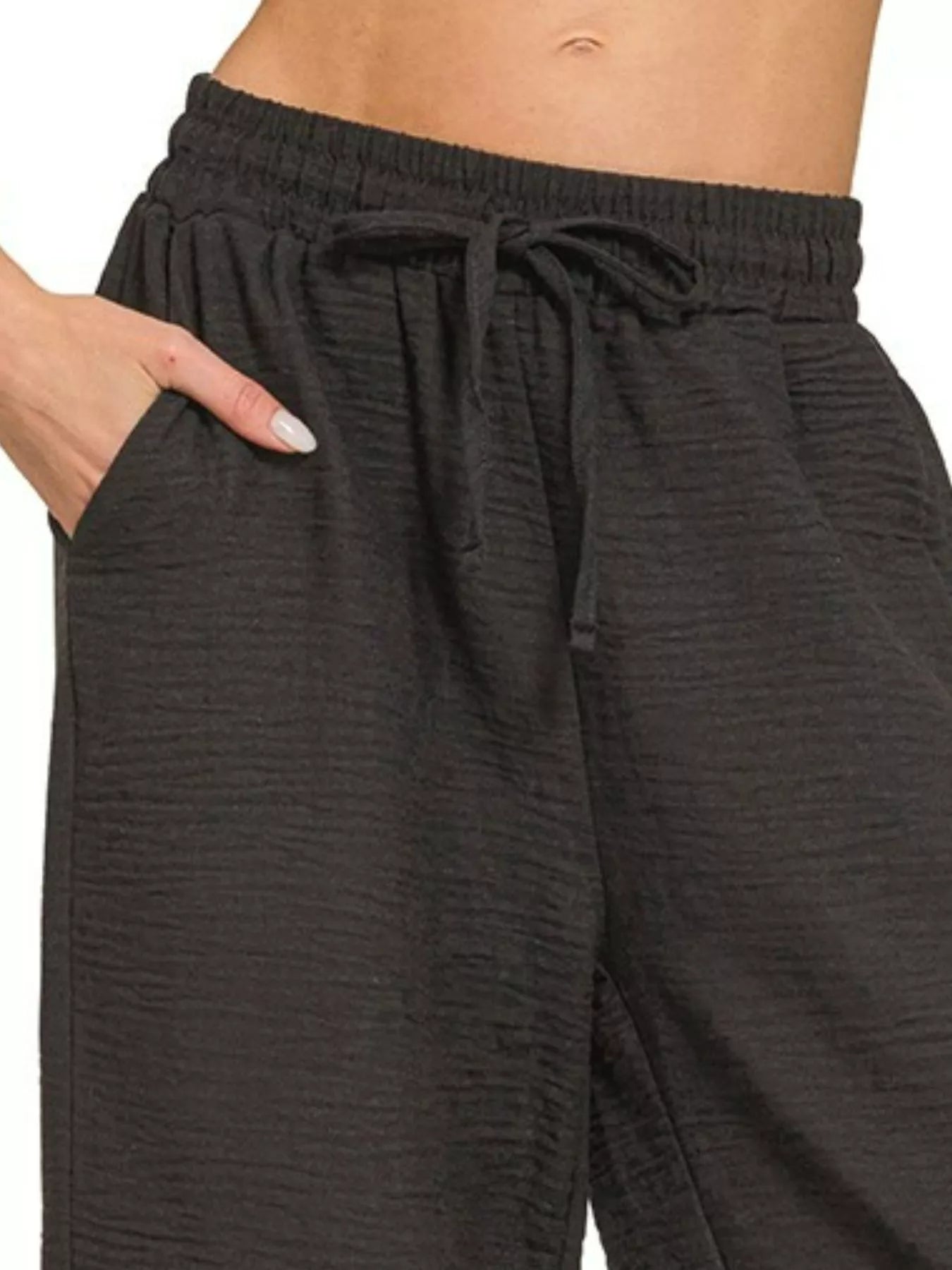 Black elastic-waist woven crepe pants with front drawstring tie and gathered waistband