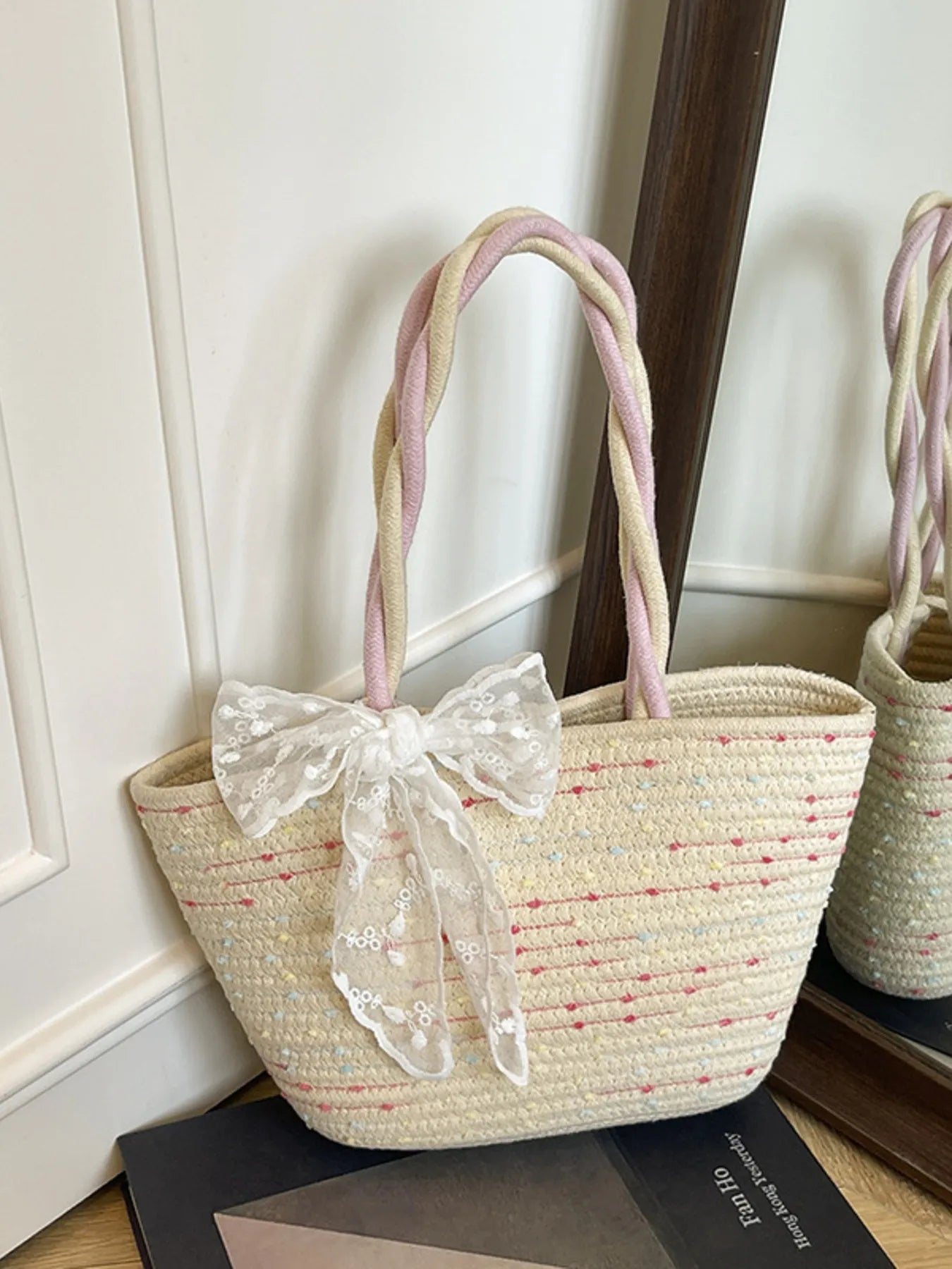Woven straw shoulder bag with large white lace bow and red-thread detail