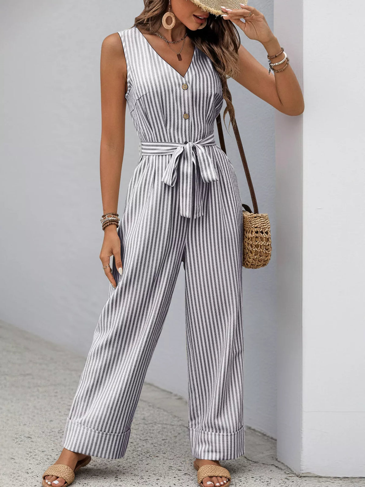 Blue-and-white striped sleeveless V-neck jumpsuit with button front and tied belt