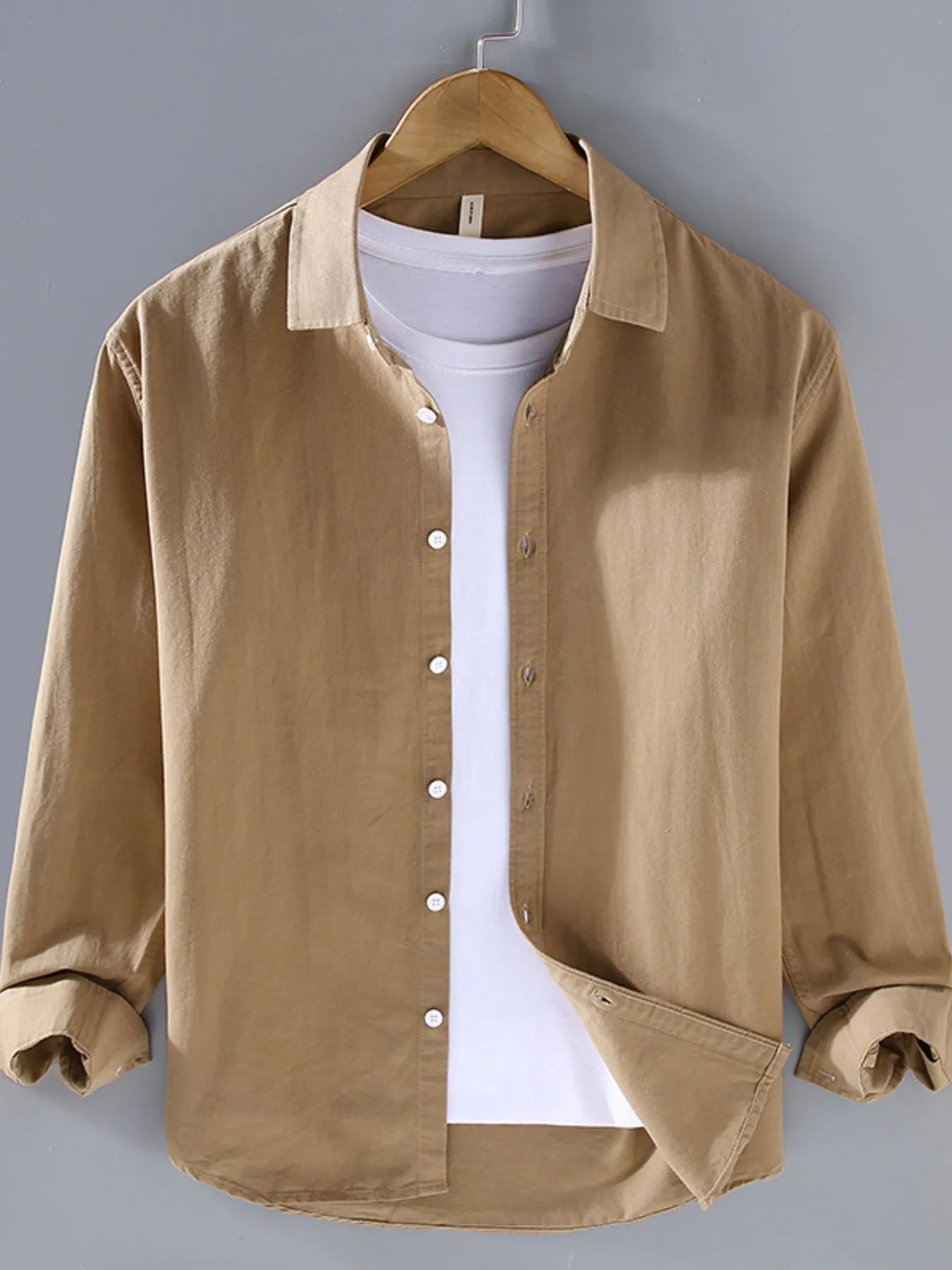 Beige button-up long sleeve shirt with pointed collar and front button placket.