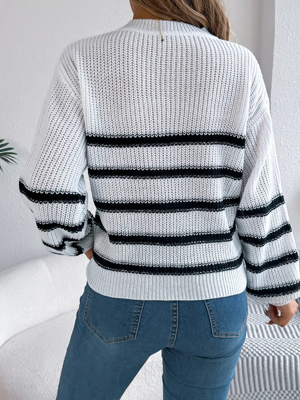 White striped knit sweater back view with round neck, long sleeves, black banding