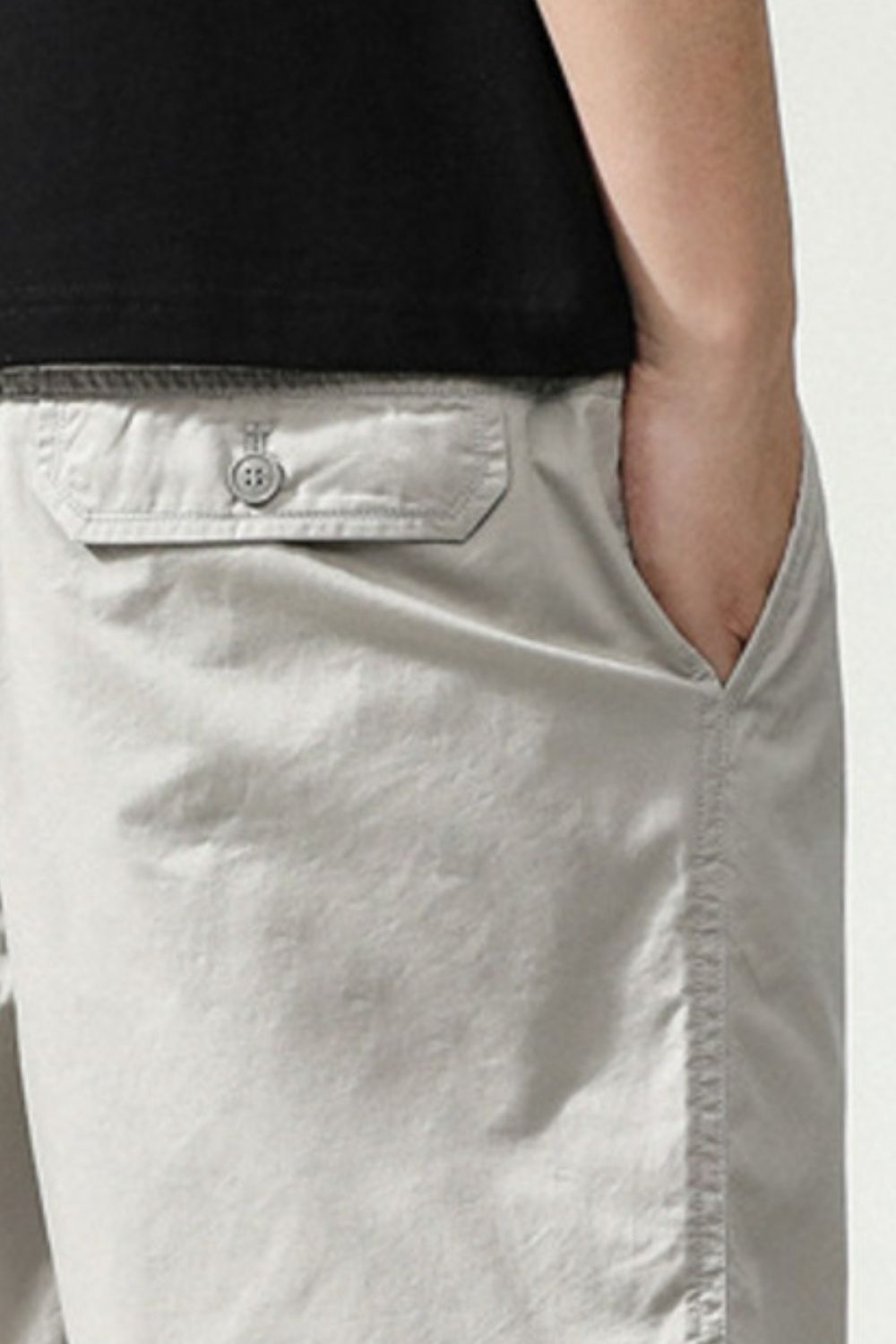 Light gray casual shorts detail with buttoned pocket flap
