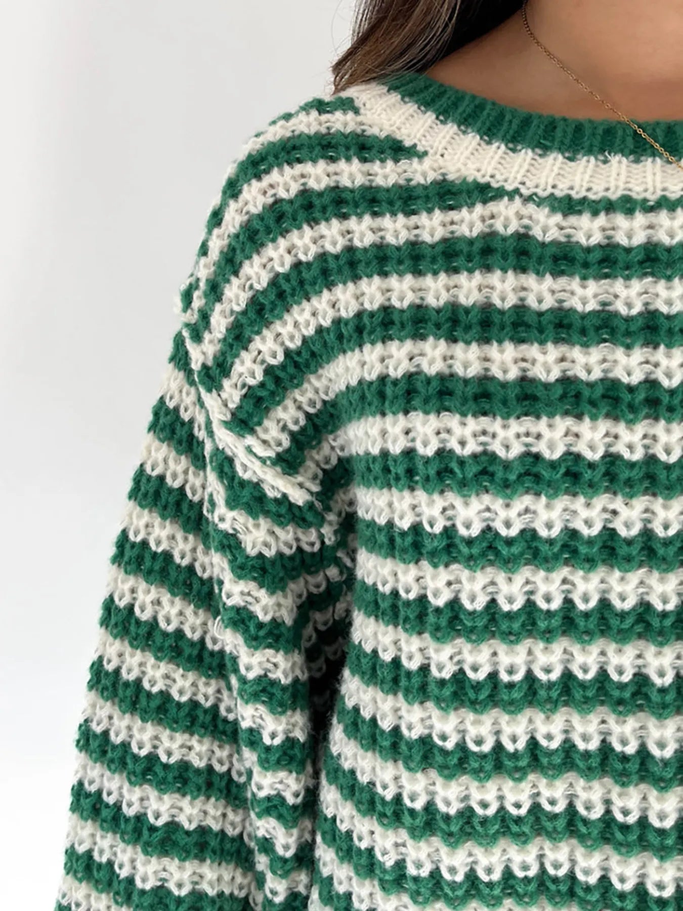 Close-up of green-and-white striped knit drop-shoulder sweater, textured stitches