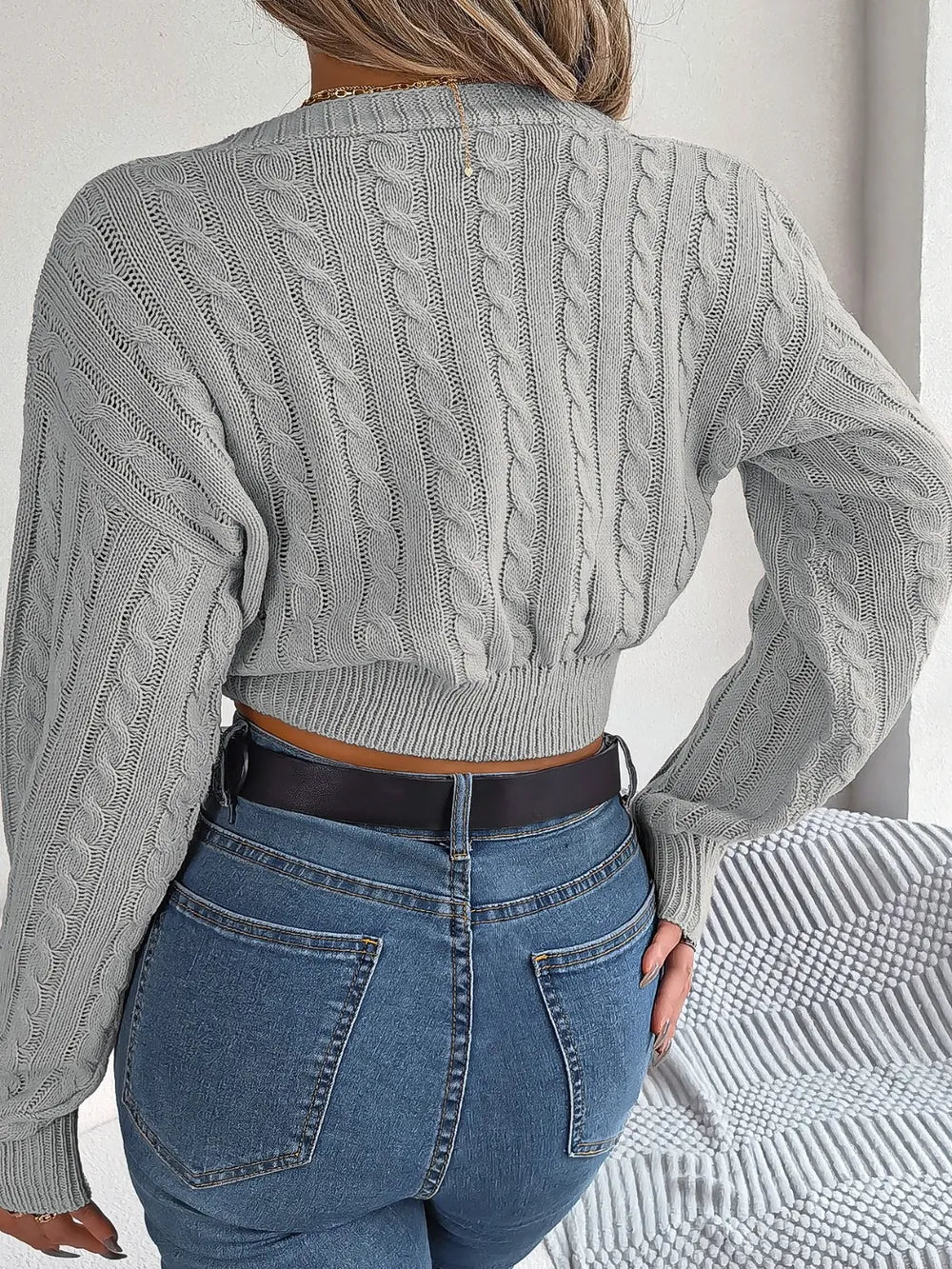 Dark gray twisted cable-knit V-neck sweater, long sleeves, back view