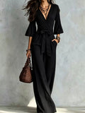 Black pleated tie-waist wide-leg jumpsuit with V-neck and belted waist
