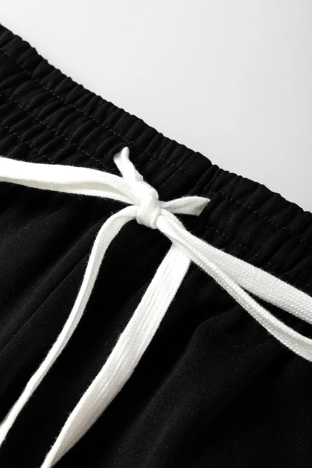 Black jogger pants with elastic waist and white drawstring