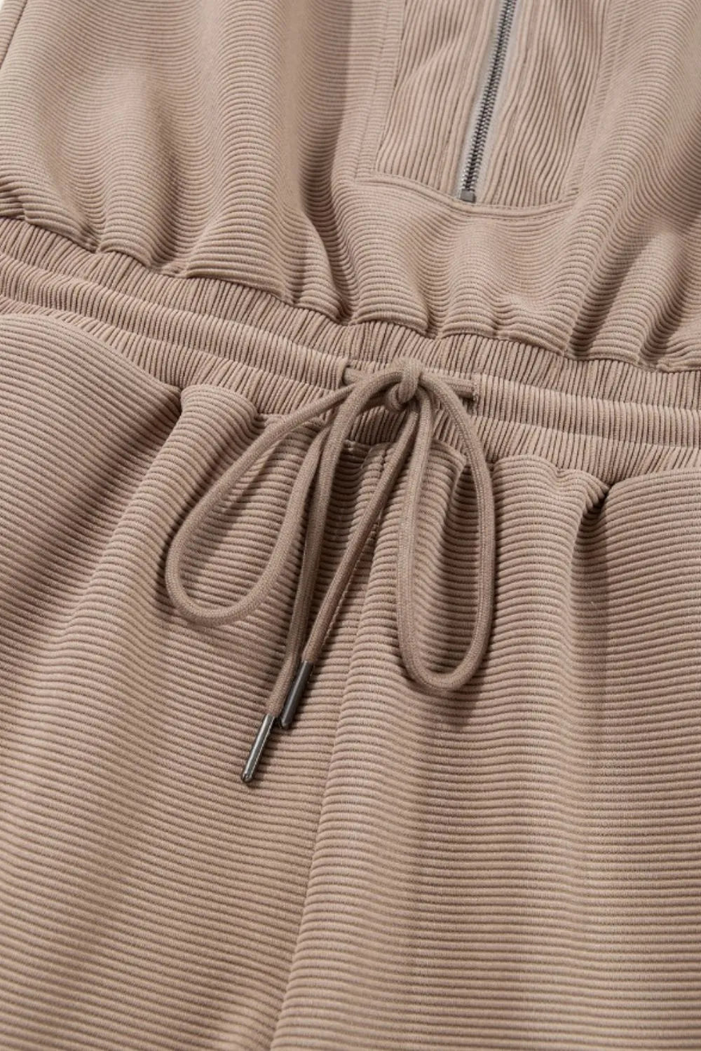 Mocha drawstring waist on a textured romper with half-zip placket