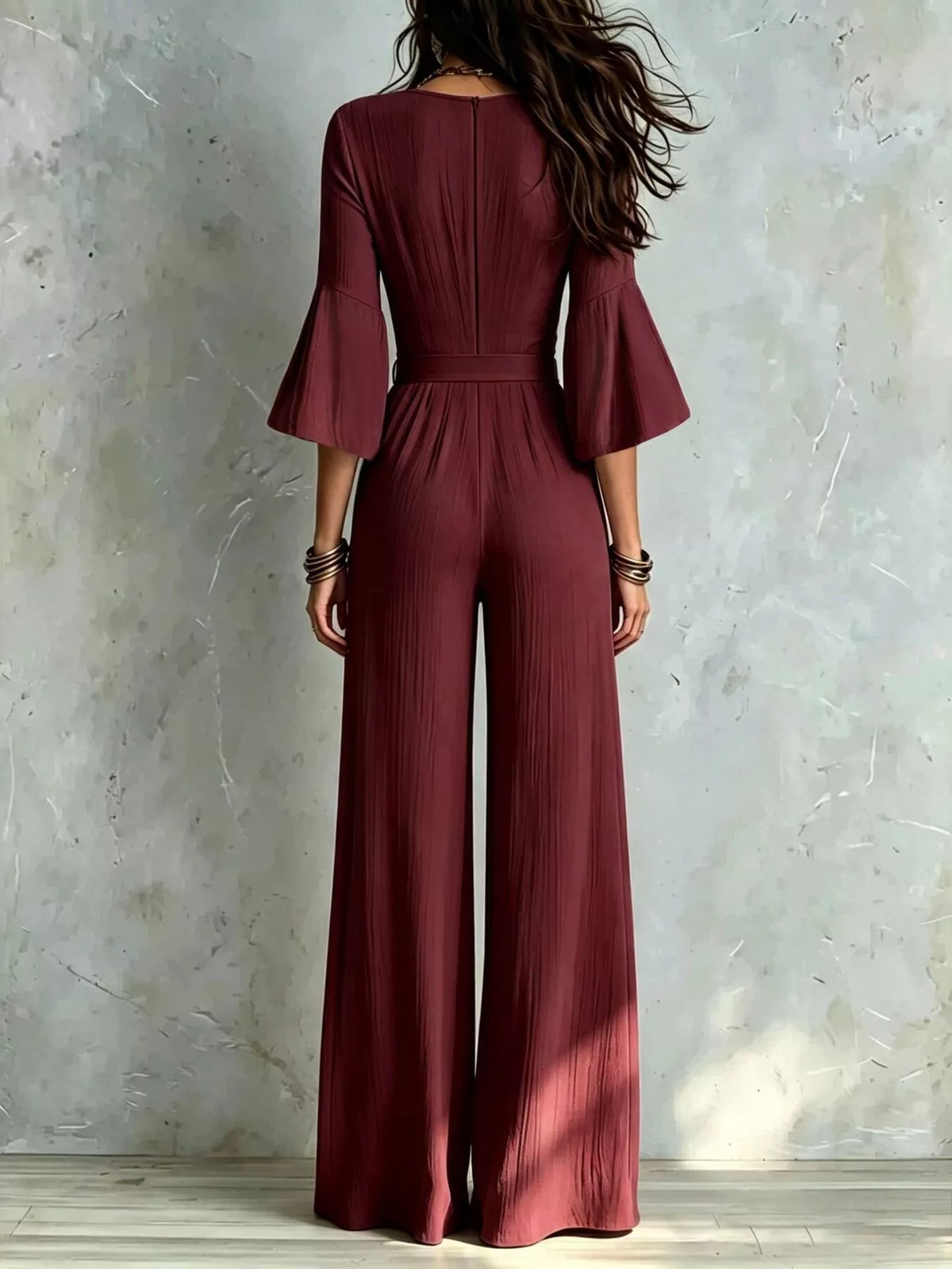 Burgundy tie-waist wide-leg jumpsuit with pleated waist and three-quarter sleeves