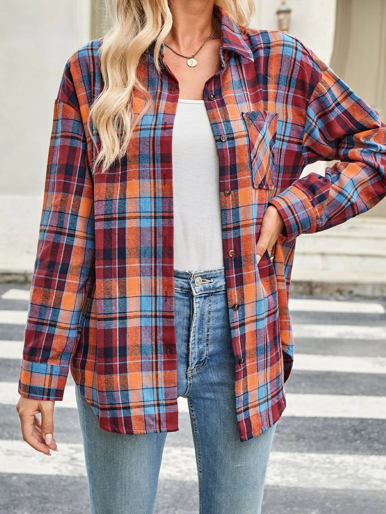 Plaid button-up long sleeve shirt in red, blue, and orange with front buttons and collar.