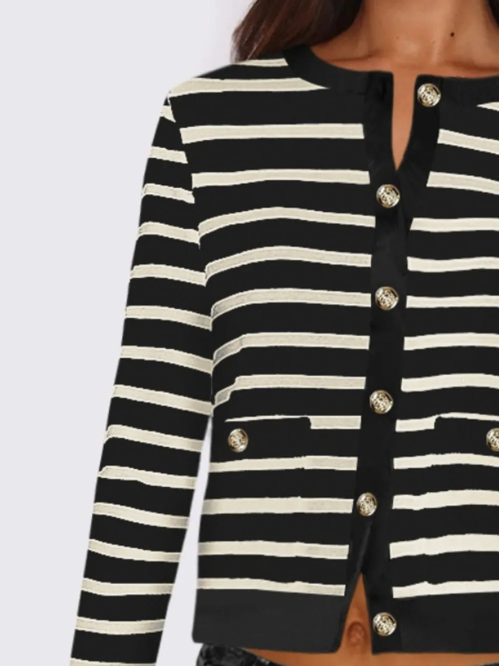 Close-up of striped cardigan front with buttons and round neckline, black and white