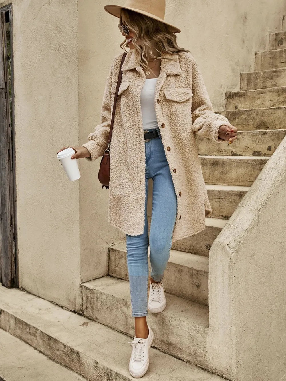 Tan sherpa collared button-front coat with flap pockets and long sleeves.