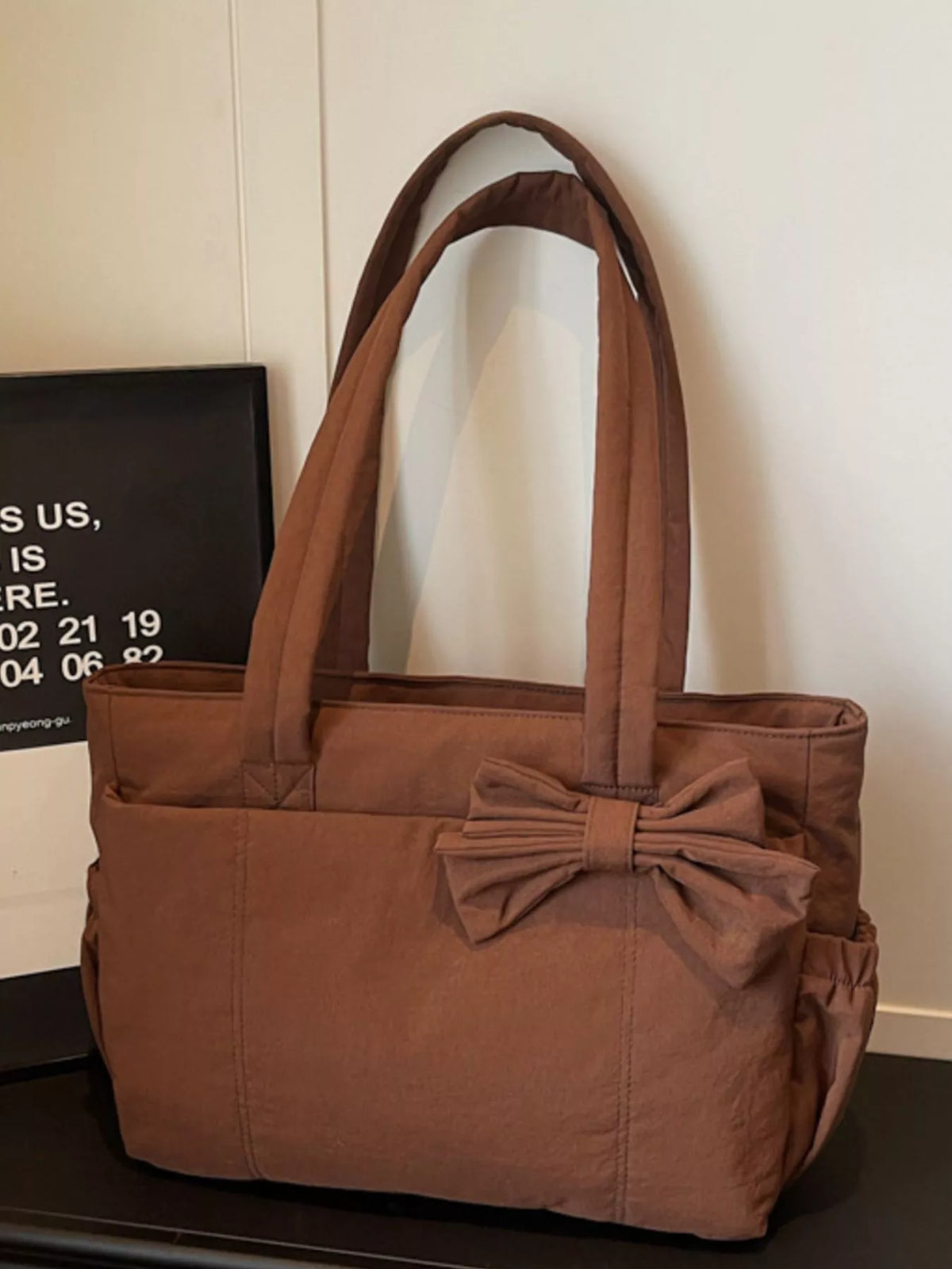 Brown medium casual tote bag with front bow accent and structured rectangular base