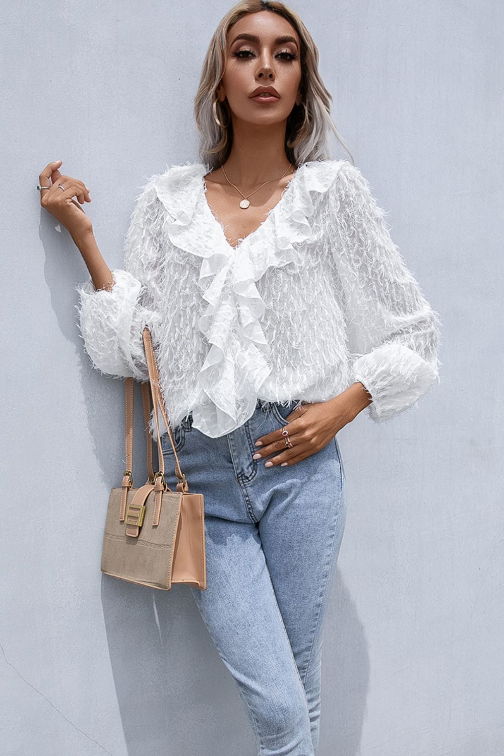 White V-neck ruffle blouse with long balloon sleeves and fringe hem